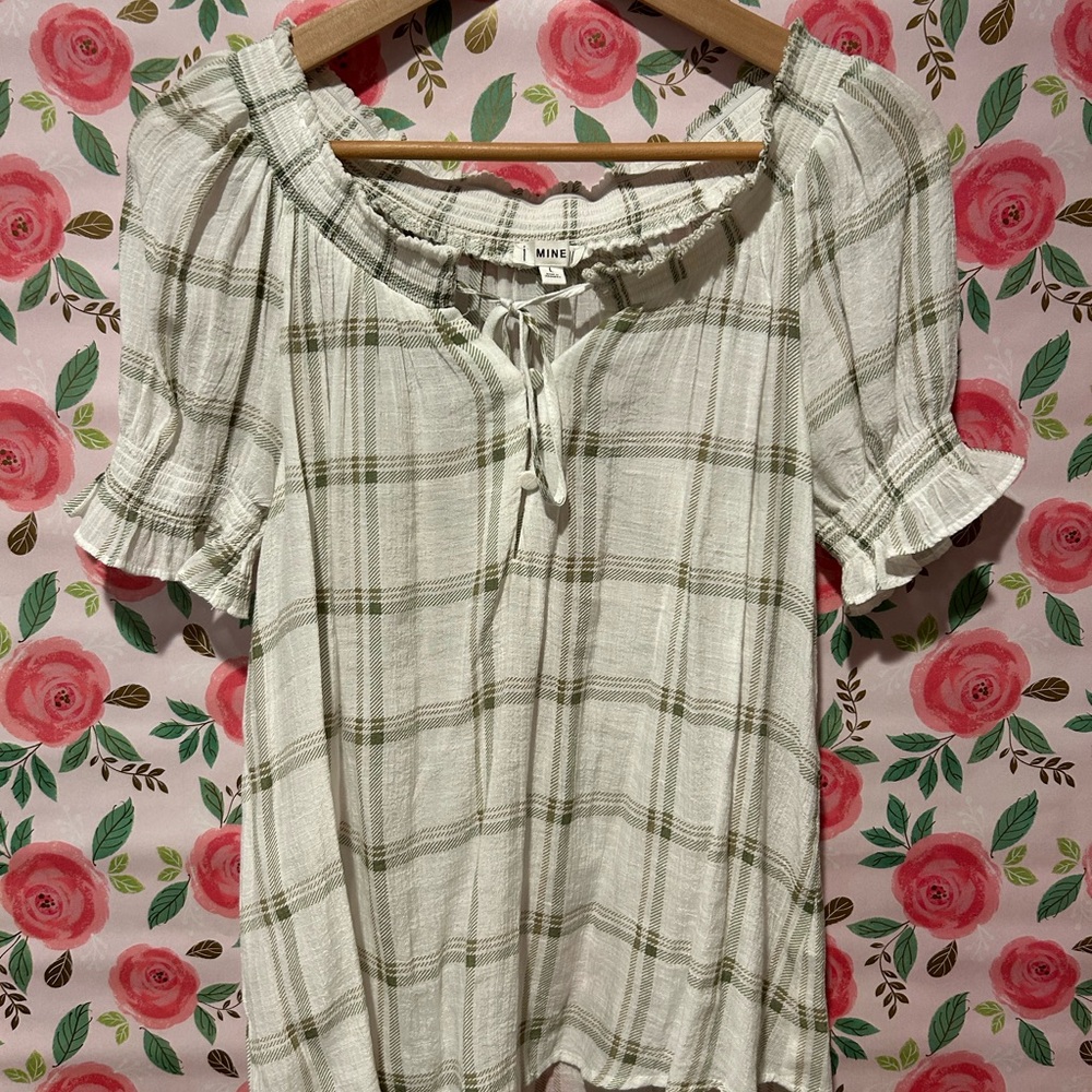 White blouse with ruffle neck and sleeve details.
